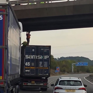 Lorry driver Dan Shillito has been praised as a 'total hero' after he stopped his vehicle under a busy motorway bridge and climbed onto the roof to save a man from taking his life. Pictured: Mr Shillito can be seen helping to hold the man up using his shoulders